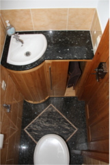 Andreas Rentsch 2008: Toilettenschrank mit in Granitplatte eingelassenem Waschbecken und gebogender Tür